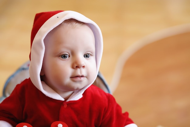 Ritratto di un bambino con gli occhi azzurri in abito rosso