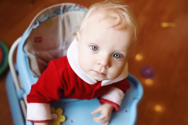 Ritratto di un bambino con gli occhi azzurri in abito rosso