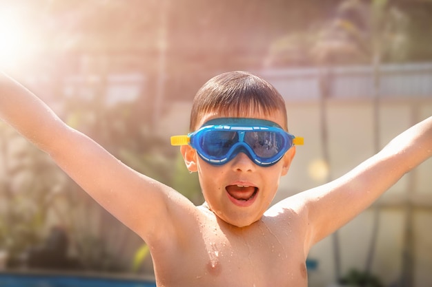 Ritratto di un bambino con gli occhiali in piscina in vacanza