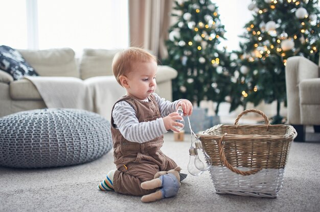 Ritratto di un bambino di 1 anno carino seduto sul pavimento.