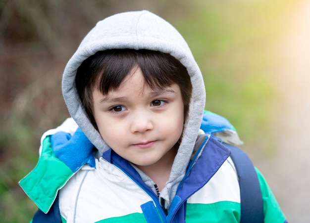 Ritratto di un bambino felice che indossa un panno caldo giocando fuori in inverno