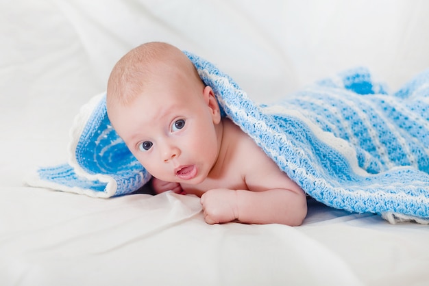 Ritratto di un bambino neonato sorridente sveglio che striscia in un pannolino