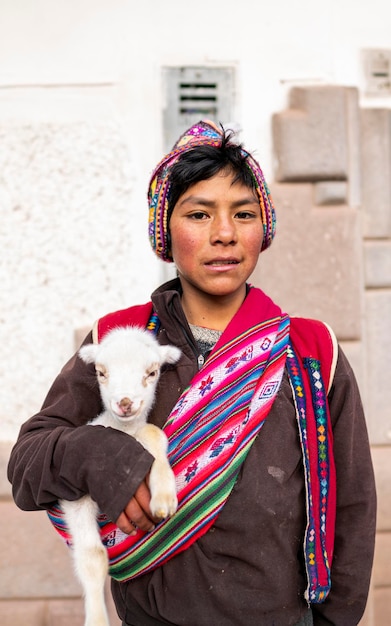 Ritratto di un bambino peruviano vestito con un costume tradizionale Cusquenian colorato fatto a mano. andino b