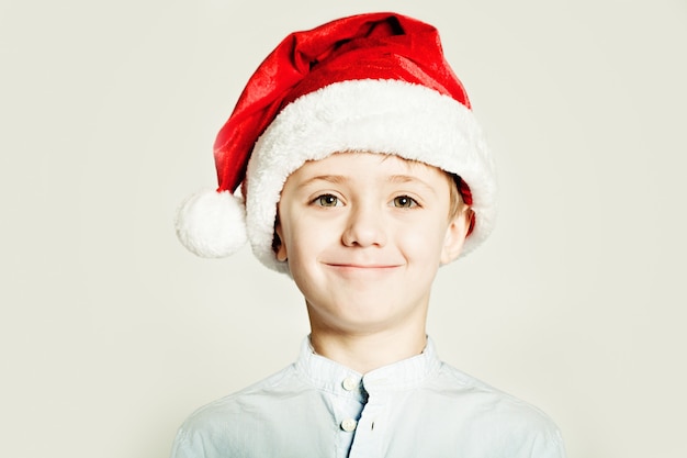 Ritratto di un bambino sorridente che indossa un cappello da Babbo Natale rosso
