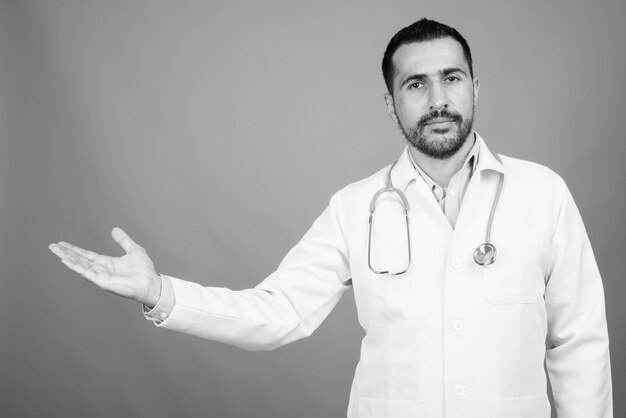 Ritratto di un bel medico persiano barbuto su grigio in bianco e nero