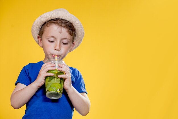 ritratto di un bel ragazzo. bambino felice. ragazzo europeo con un cappello, maglietta estiva con limonata