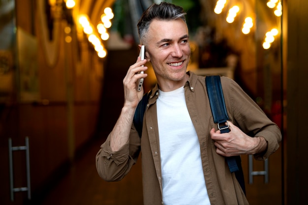 Ritratto di un bell'uomo che utilizza lo smartphone in città