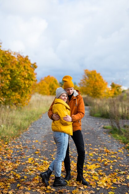 Ritratto di un bell'uomo e di una bella donna che si abbracciano nel parco autunnale