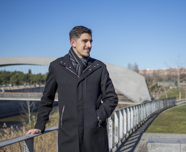 Ritratto di un bell'uomo in piedi sulla strada, modello di moda in piedi all'aperto