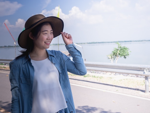 Ritratto di un cappello da portare della bella giovane donna asiatica