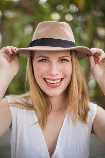 Ritratto di un cappello da portare sorridente della donna bionda