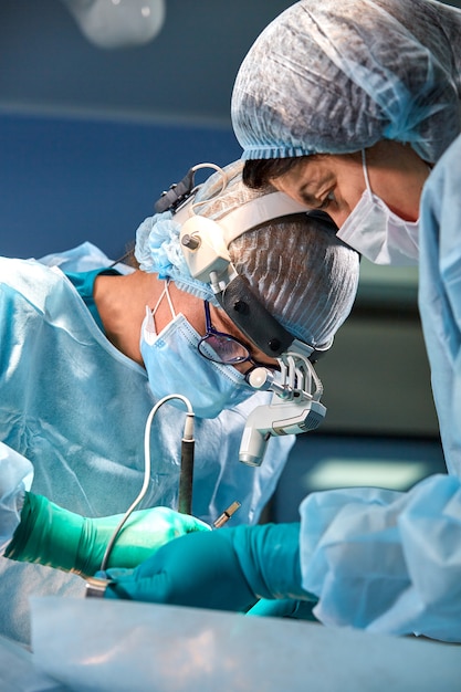 Ritratto di un chirurgo di close-up. I chirurghi operano su un paziente. Volti tesi, seri. Operazione reale. Atmosfera tesa in sala operatoria.