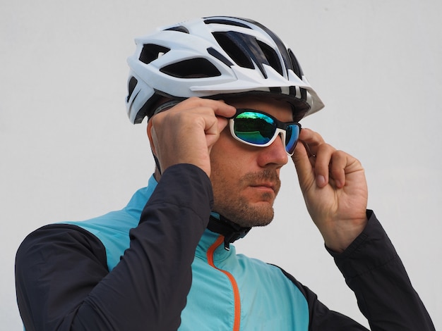 Ritratto di un ciclista maschio in un casco che indossa occhiali da sole.