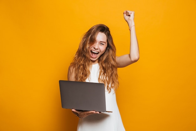 Ritratto di un computer portatile felice della holding della ragazza