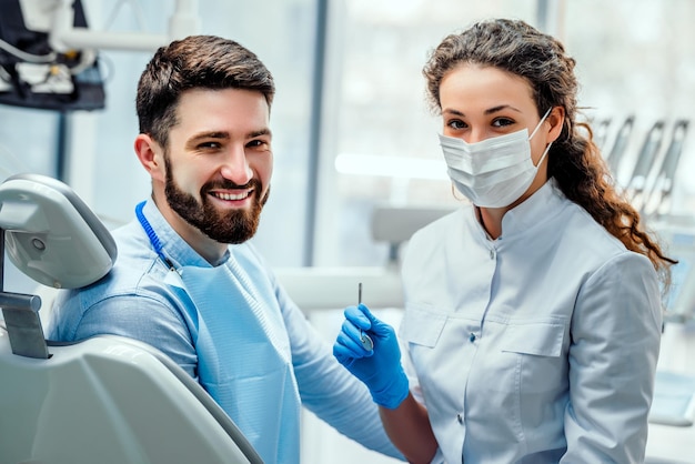 Ritratto di un dentista femminile e di un giovane in uno studio dentistico