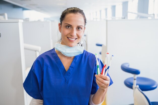 Ritratto di un dentista sorridente che mostra spazzolino da denti