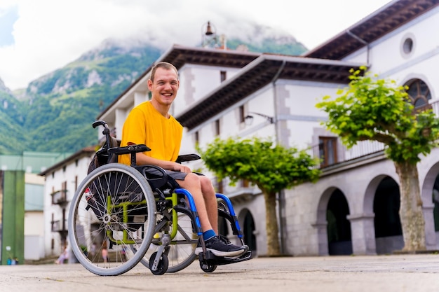 Ritratto di un disabile in sedia a rotelle che cammina per la piazza del paese
