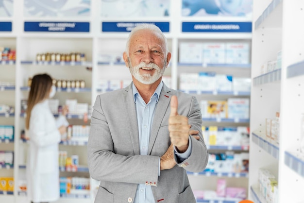 Ritratto di un farmacista maschio che mostra un segno di approvazione con il pollice della mano in su