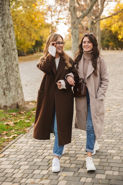 Ritratto di un felice allegro ottimista giovani donne amici che camminano all'aperto nel parco naturale verde.