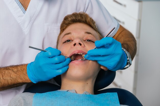 Ritratto di un giovane all'ispezione dentale nell'ufficio del dentista.