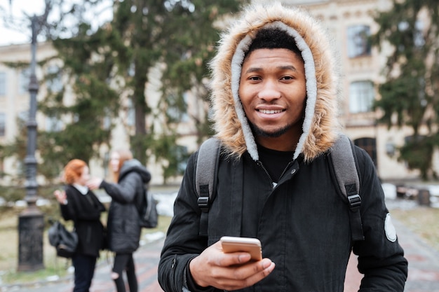 Ritratto di un giovane studente africano che tiene il cellulare