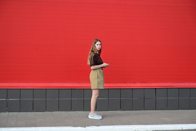 Ritratto di un giovane studente che legge un messaggio su un telefono cellulare una bella ragazza elegante che chiacchiera su un telefono cellulare mentre cammina per strada disturbo sociale disturbo tecnologia dipendente dalla malattia