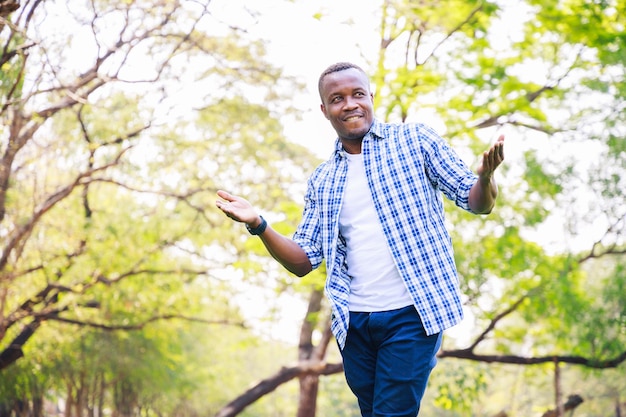 Ritratto di un giovane uomo afroamericano felice nel parco Concetto di persone fiduciose