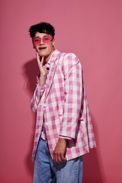 Ritratto di un giovane uomo con fiducia in se stessi rosa plaid blazer moda in posa sfondo rosa inalterato