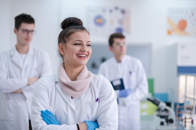 ritratto di un gruppo di giovani studenti di medicina in piedi insieme nel laboratorio di chimica, lavoro di squadra di studenti universitari al chiuso