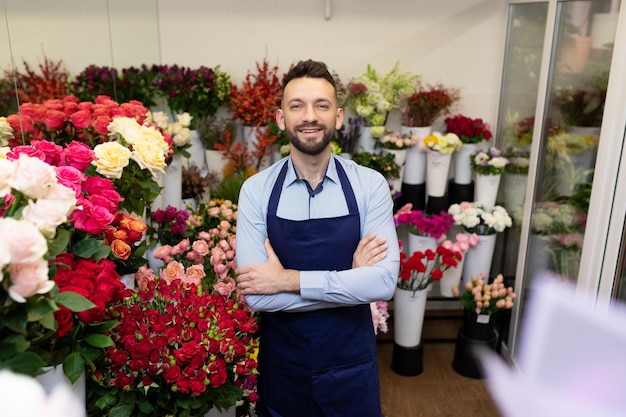 Ritratto di un imprenditore di fiori sorridente circondato da mazzi di fiori colorati