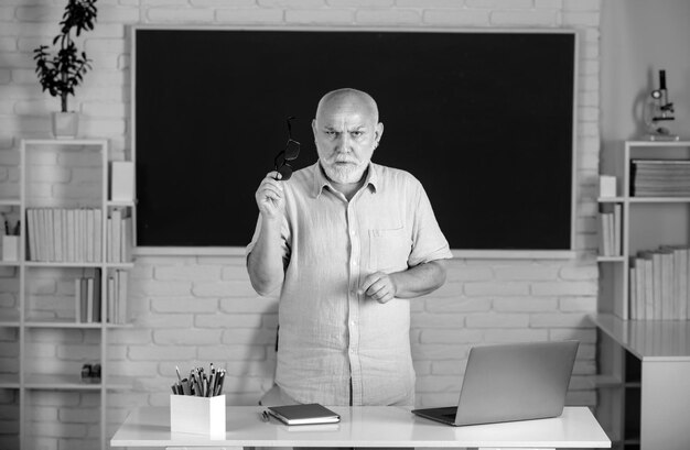 Ritratto di un insegnante anziano caucasico sicuro di sé in classe un uomo di mezza età professore al liceo