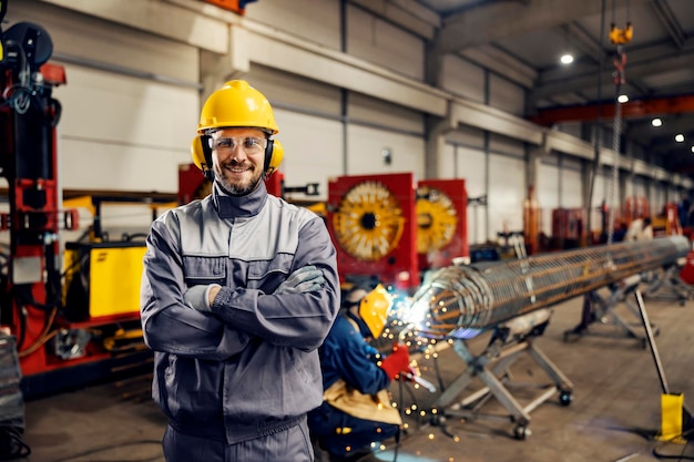 Ritratto di un lavoratore sorridente dell'industria pesante che posa nella funzione