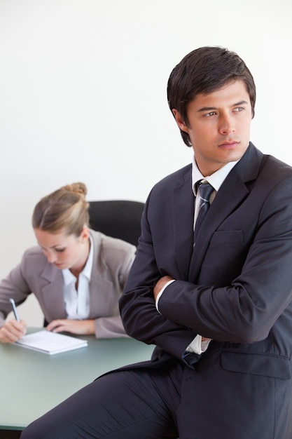 Ritratto di un manager in posa mentre il suo collega sta lavorando