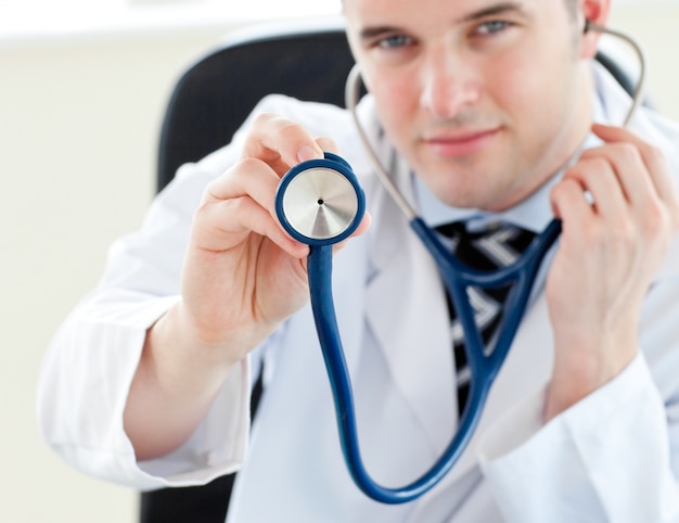 Ritratto di un medico maschio affascinante che tiene uno stetoscopio