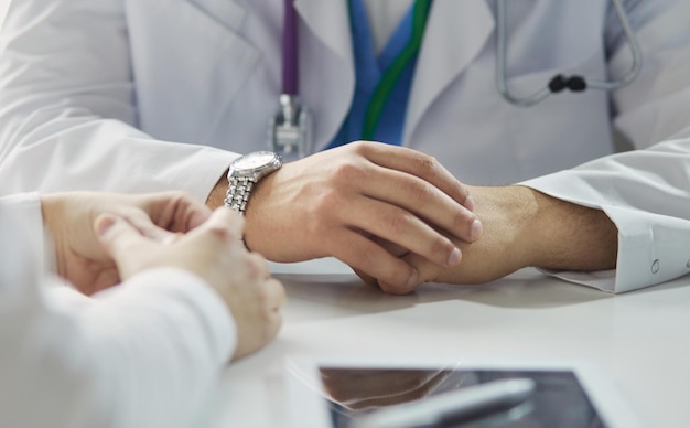 Ritratto di un medico maschio con il computer portatile seduto alla scrivania in studio medico