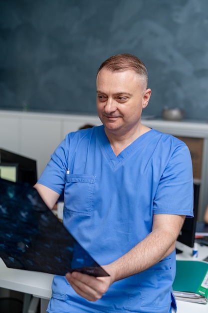 Ritratto di un medico sorridente. Specialista medico maschile. Chirurgo o radiologo sullo sfondo della sala medica.