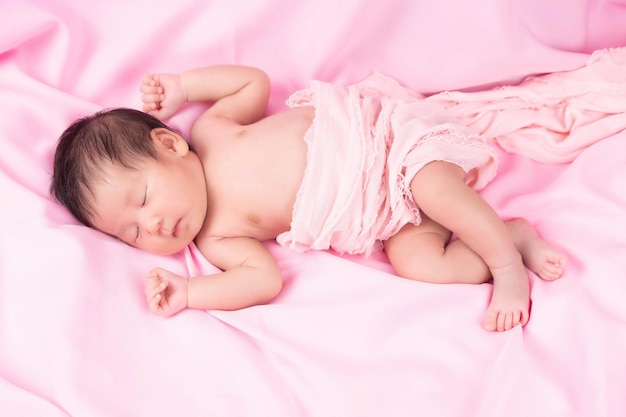 Ritratto di un mese di età che dorme, neonata su una coperta rosa. Concetto ritratto studio moda neonato.