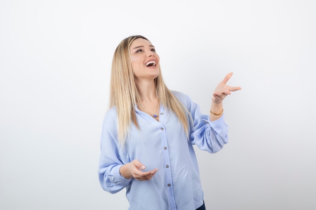 Ritratto di un modello di donna graziosa sorridente in piedi e alzando lo sguardo.