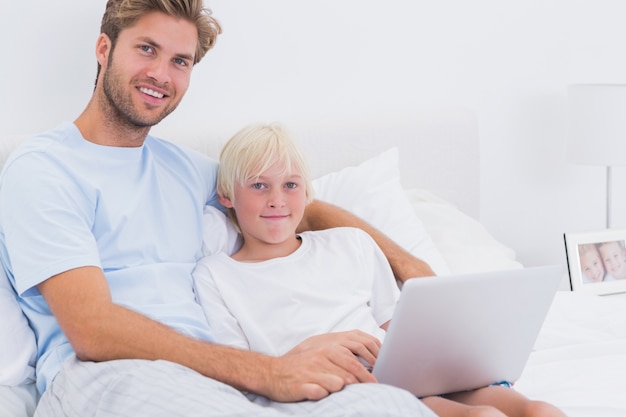 Ritratto di un padre e suo figlio utilizzando un computer portatile