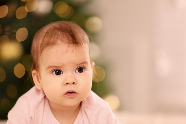 Ritratto di un piccolo bambino carino contro luci festive sfocate spazio per il testo Vacanze invernali