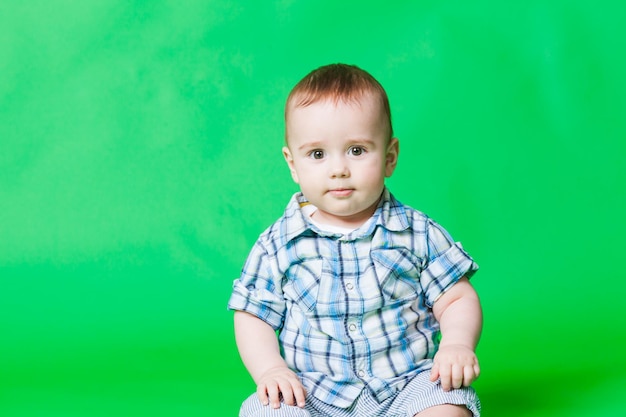 Ritratto di un piccolo bambino curioso, guardando la telecamera. Isolato su sfondo verde