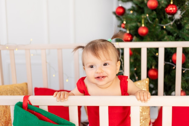 Ritratto di un piccolo bambino felice in una culla a casa dall'albero di Natale