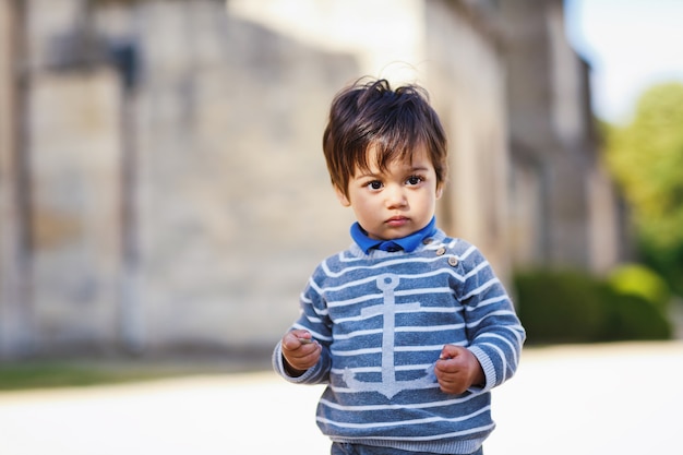 Ritratto di un piccolo neonato bello orientale che gioca all'aperto nel parco.