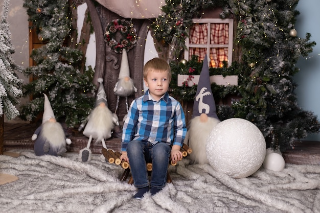 Ritratto di un ragazzino allegro vicino all'albero di Natale