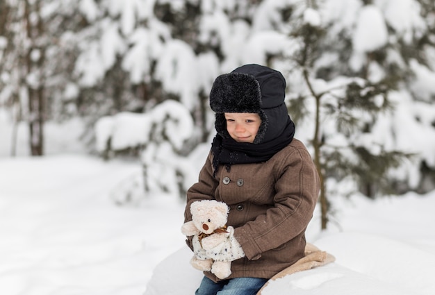 ritratto di un ragazzino in una foresta invernale