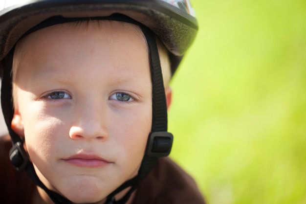 Ritratto di un ragazzino positivo su una bicicletta all&#39;aperto