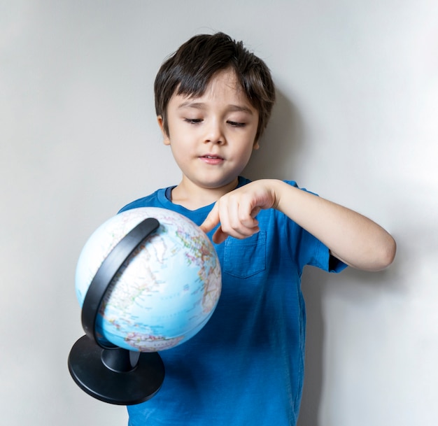 Ritratto di un ragazzo che tiene il globo del mondo