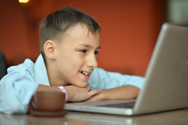 Ritratto di un ragazzo con laptop sul tavolo