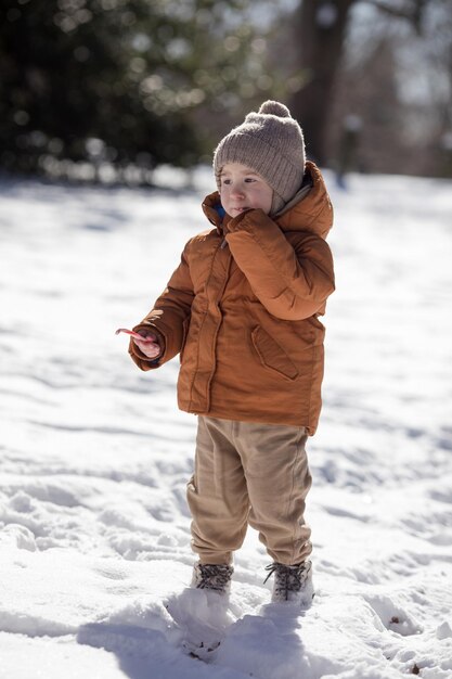 Ritratto di un ragazzo di due anni in piedi nella neve fresca in inverno che gioca all'aperto