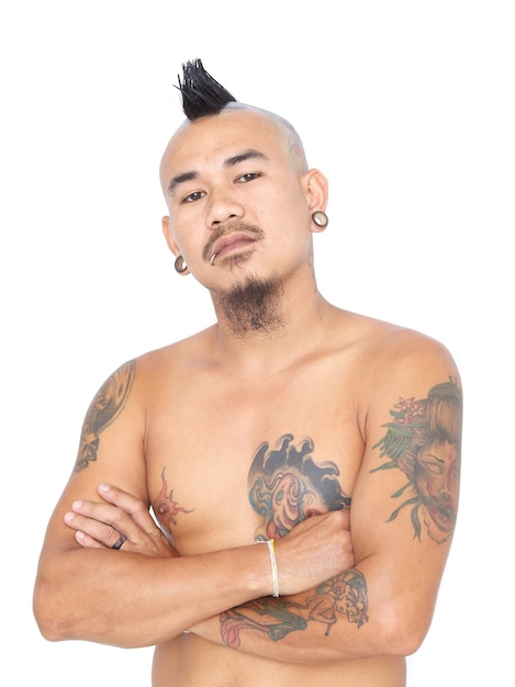 Ritratto di un ragazzo punk asiatico arrabbiato e pazzo con stile di capelli mohawk, piercing e tatuaggio isolato su uno sfondo bianco